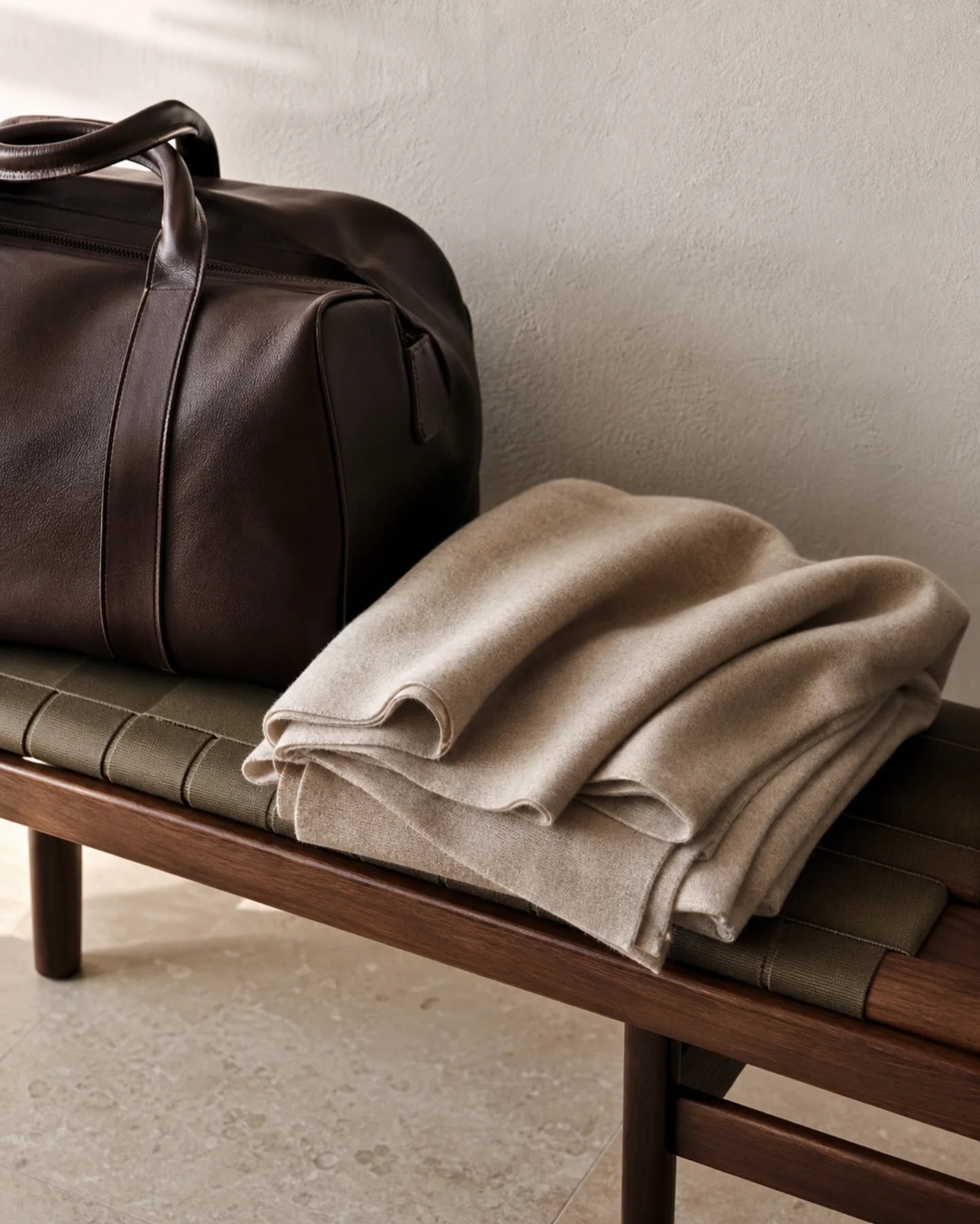 Oat cashmere travel wrap beside an espresso leather weekender